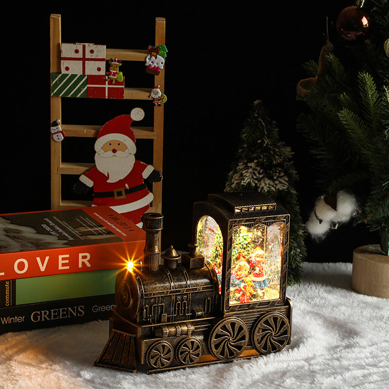Decorative train lamp with Christmas scene inside, surrounded by festive items on a dark background.