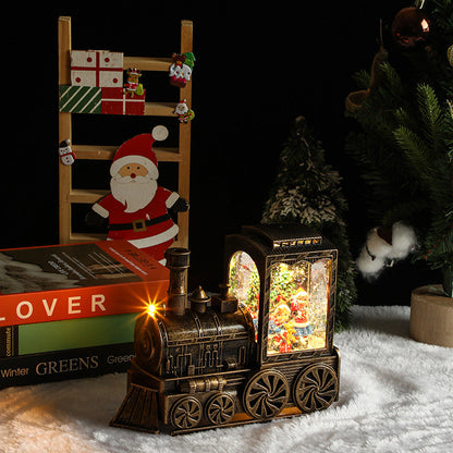 Decorative train lamp with Christmas scene inside, surrounded by festive items on a dark background.