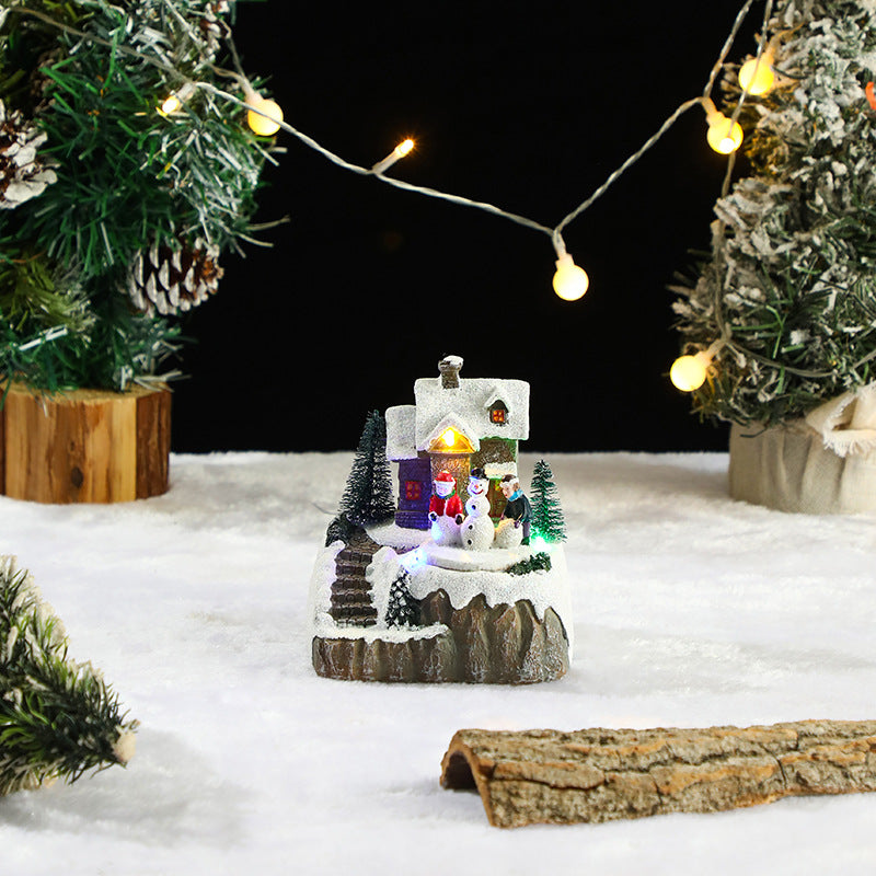 Miniature Christmas scene with a snowman, trees, and lights on a snowy background