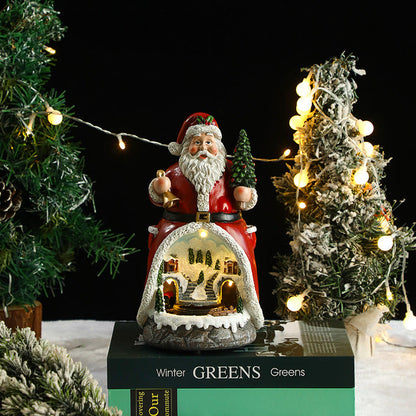 Decorative Santa Claus figure with a lit-up scene on a table with Christmas trees and lights.