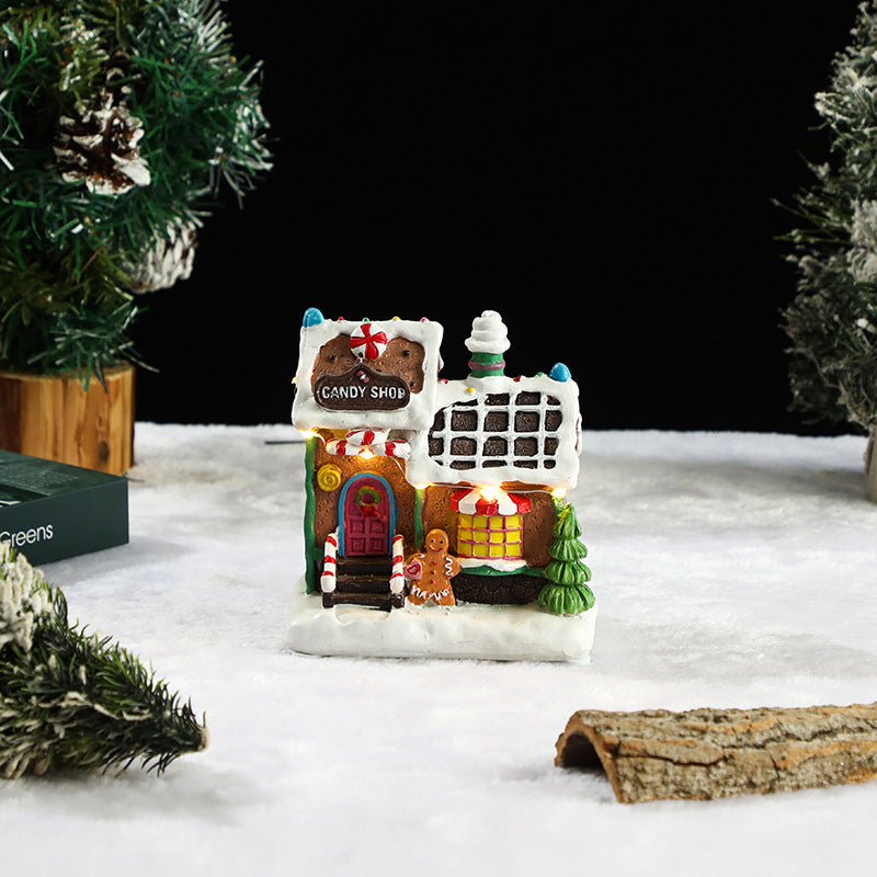 Gingerbread house candy shop model on a snowy landscape with Christmas trees.