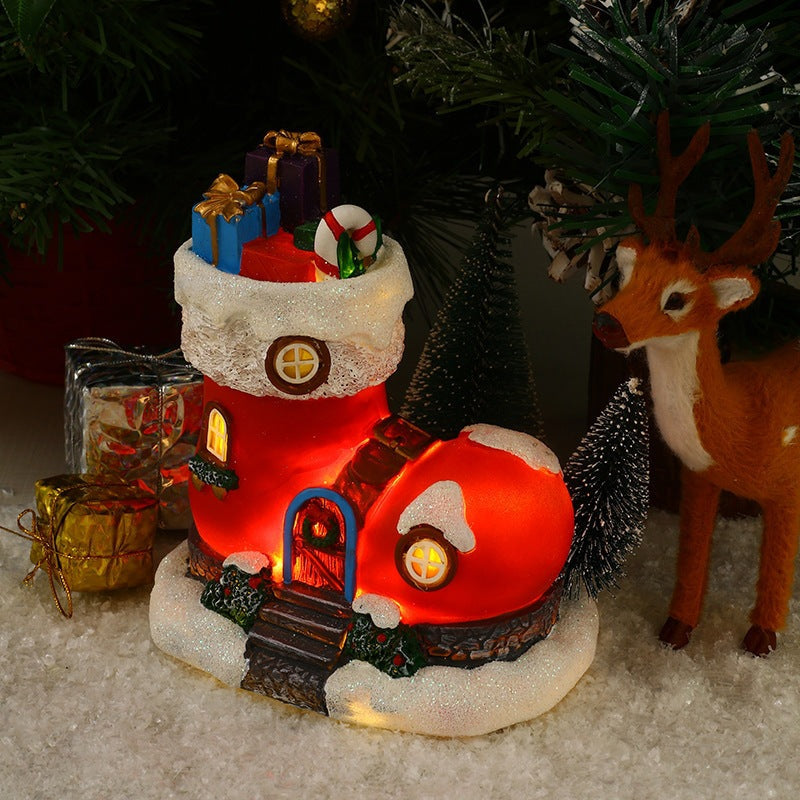 Decorative Christmas scene with a lit-up boot filled with gifts, a reindeer, and presents on a snowy surface.