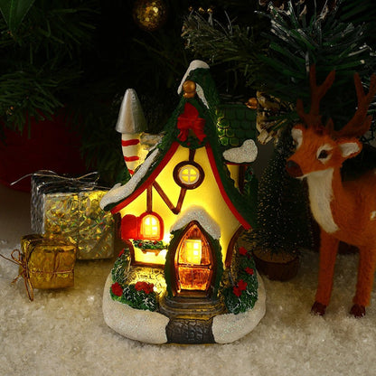 Decorative Christmas scene with a lit gingerbread house, reindeer, and presents.
