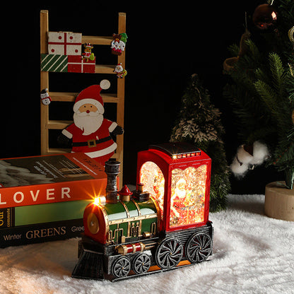 Decorative train lamp with glowing lights on a snowy surface, surrounded by Christmas decorations.