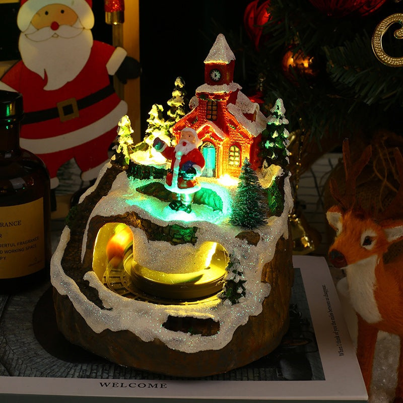 Decorative Christmas scene with a lit-up house, trees, and Santa Claus figure.