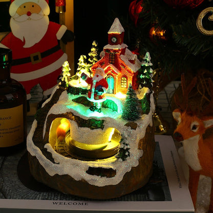 Decorative Christmas scene with a lit-up house, trees, and Santa Claus figure.