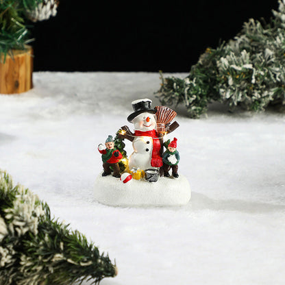 Miniature Snowman and child figure decorating a Christmas tree in a snowy scene.