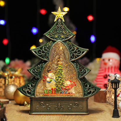 Decorative Christmas tree-shaped snow globe with a glowing interior scene.
